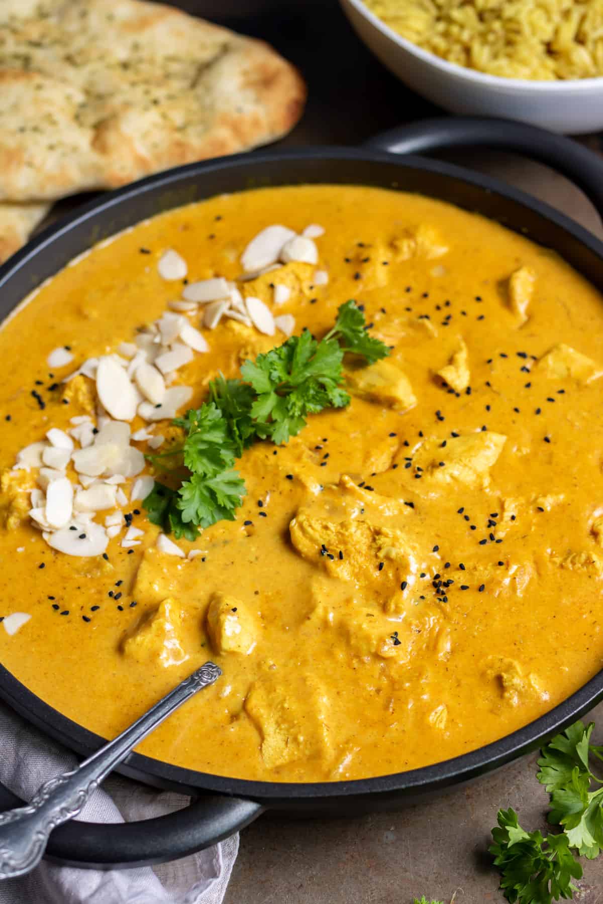 Spoon in a serving dish of slow cooker chicken korma.