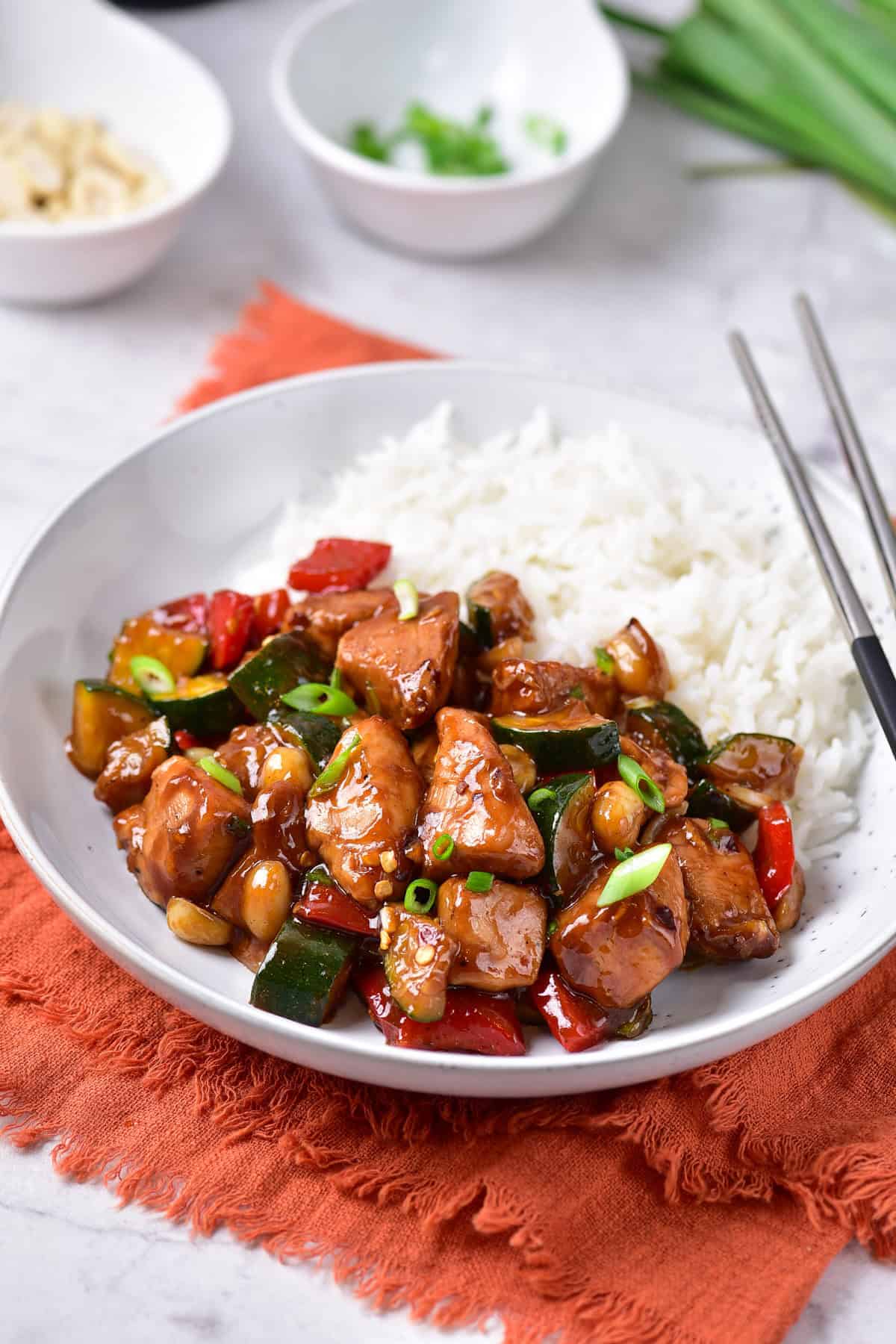 A table with a dish of kung pao chicken.