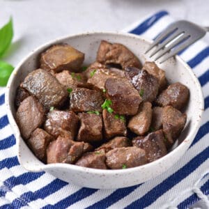 Bowl of garlic butter steak bites on a table.