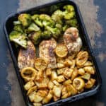 Looking down at the pan of sheet pan baked chicken breasts and potatoes and broccoli.