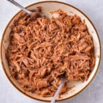 Two forks in a bowl of mexican pulled pork aka Pork Carnitas.