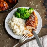 Looking down a dish of soy glazed chicken thats been cut open.