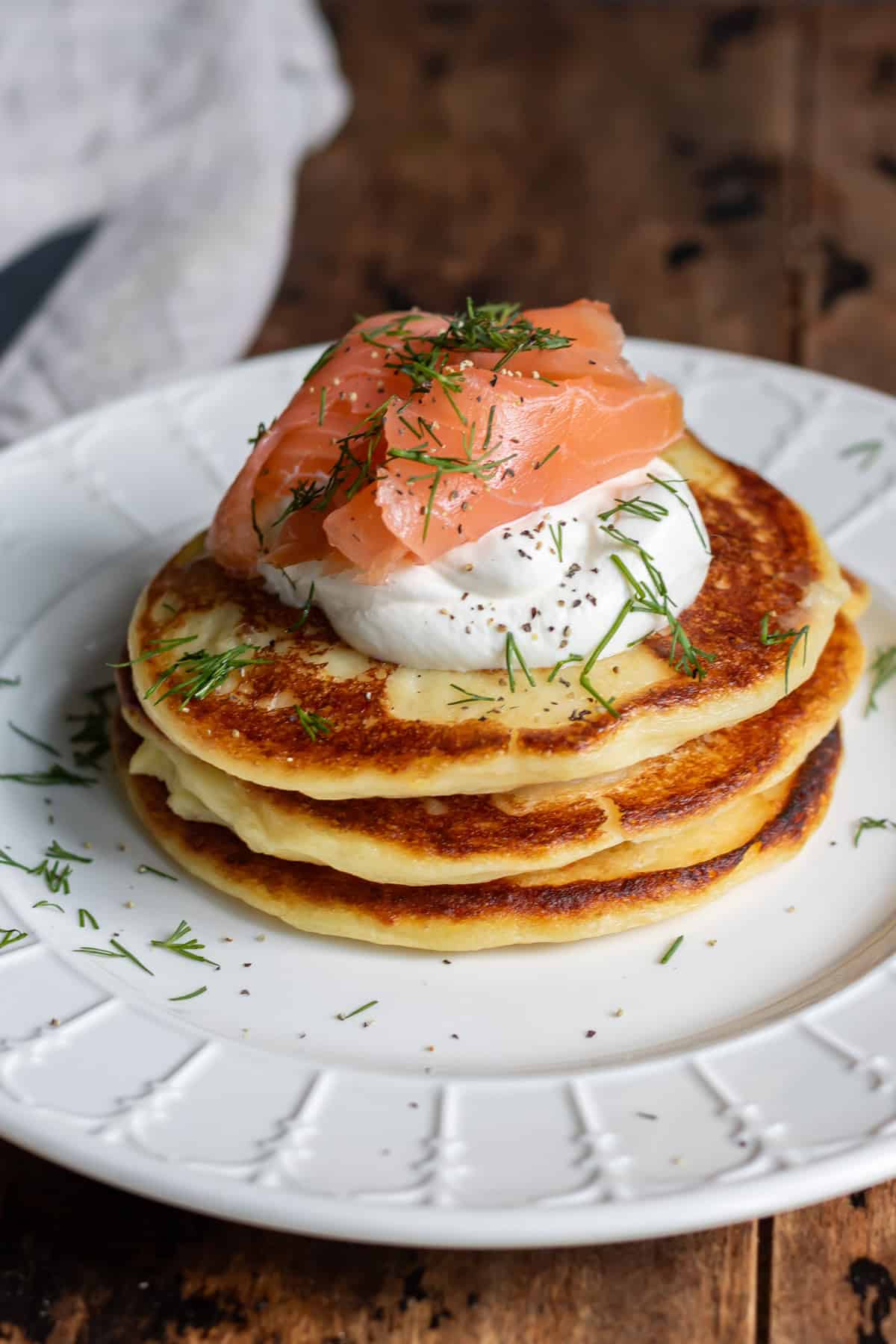 Looking down at a plate of mashed potato pancakes with smoked salmon.