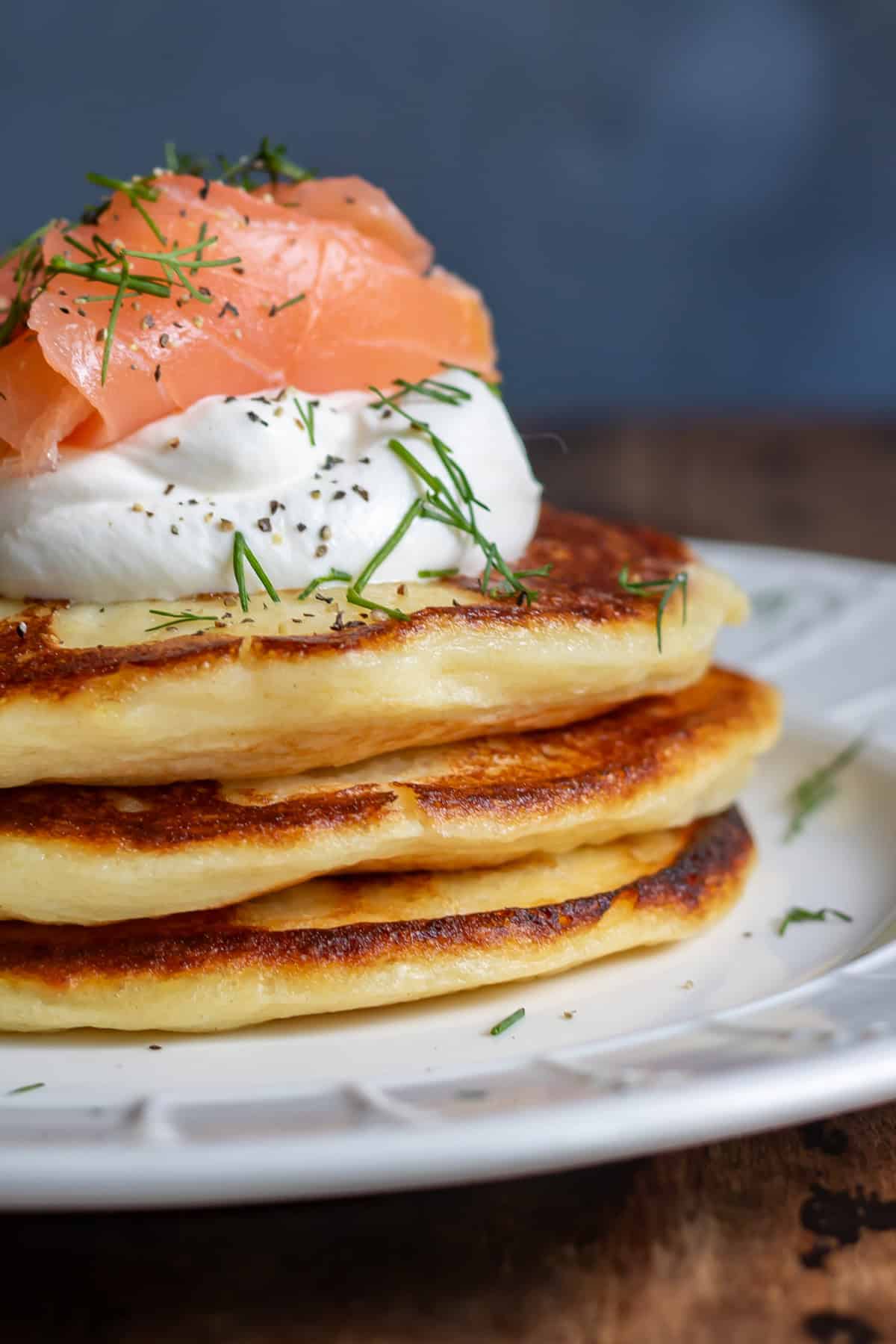 Side view close up of a stack of mashed potato pancakes with smoked salmon.