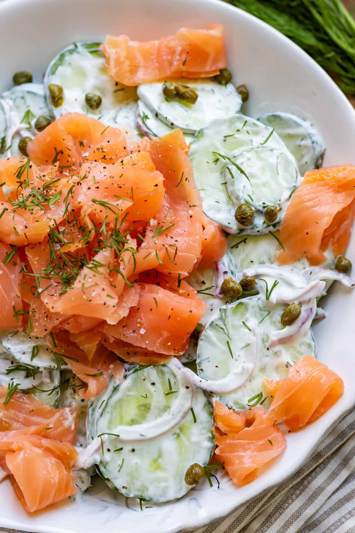 Close up of a bowl of smoked salmon cucumber salad.