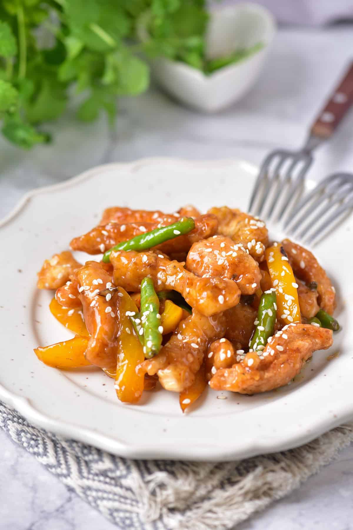 A table with a plate of copycat Panda Express honey sesame chicken.
