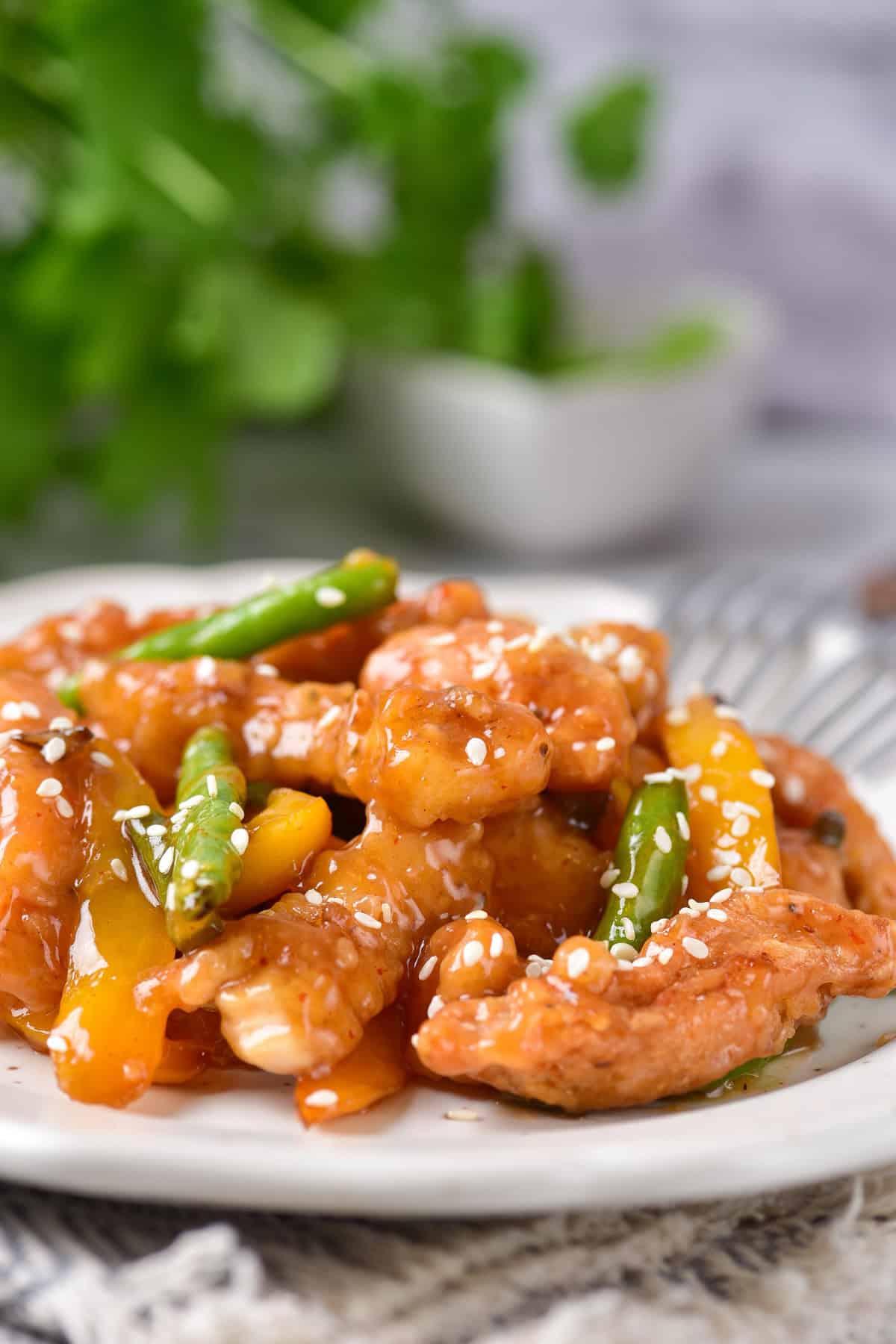 Side view of a plate of Panda Express honey sesame chicken.