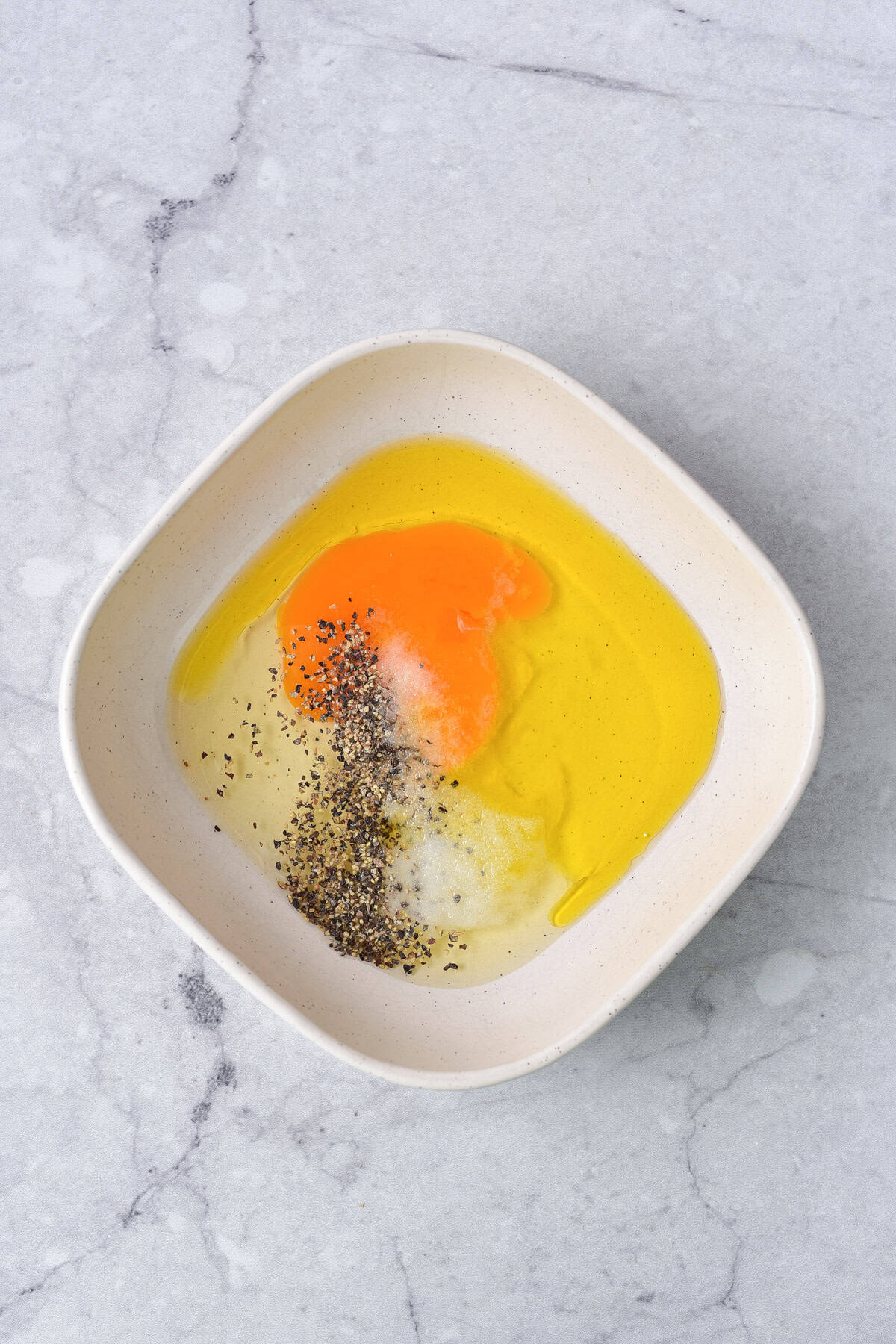 Egg, oil and seasonings in a bowl.