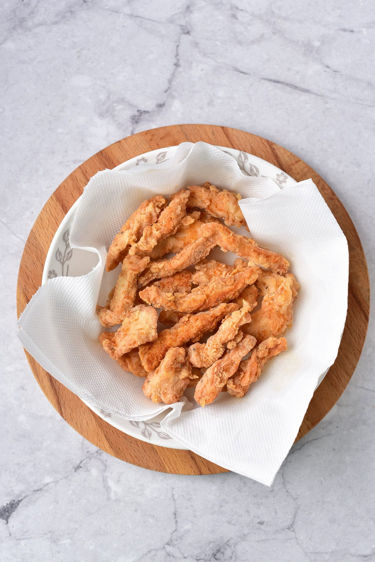 Draining the fried chicken strips.