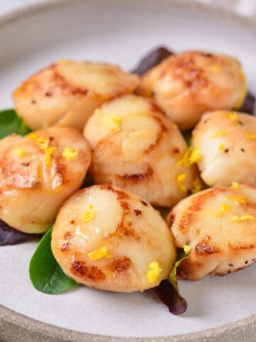 Plate of lemon butter pan seared scallops.