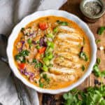 Looking down at a table with a bowl of Thai Chicken Soup with rice.
