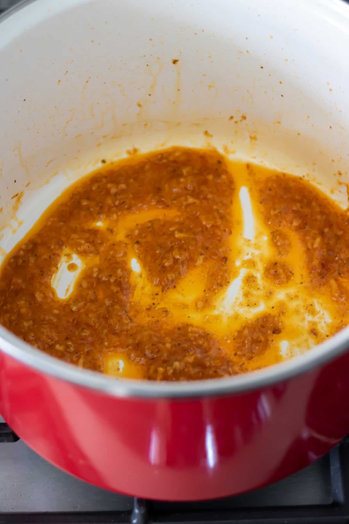 Thai red curry paste, garlic and ginger in a pot.