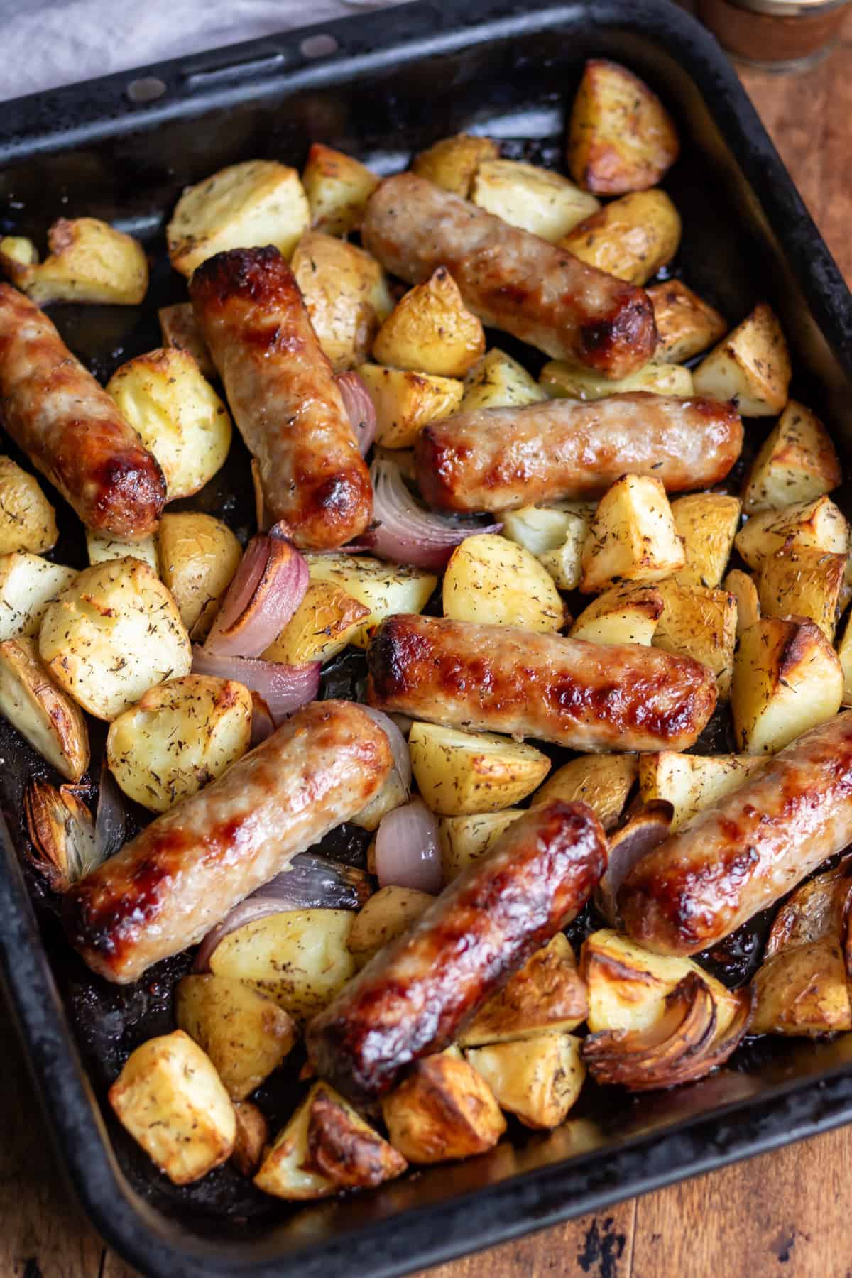 A baking sheet with cooked potato sausage bake.