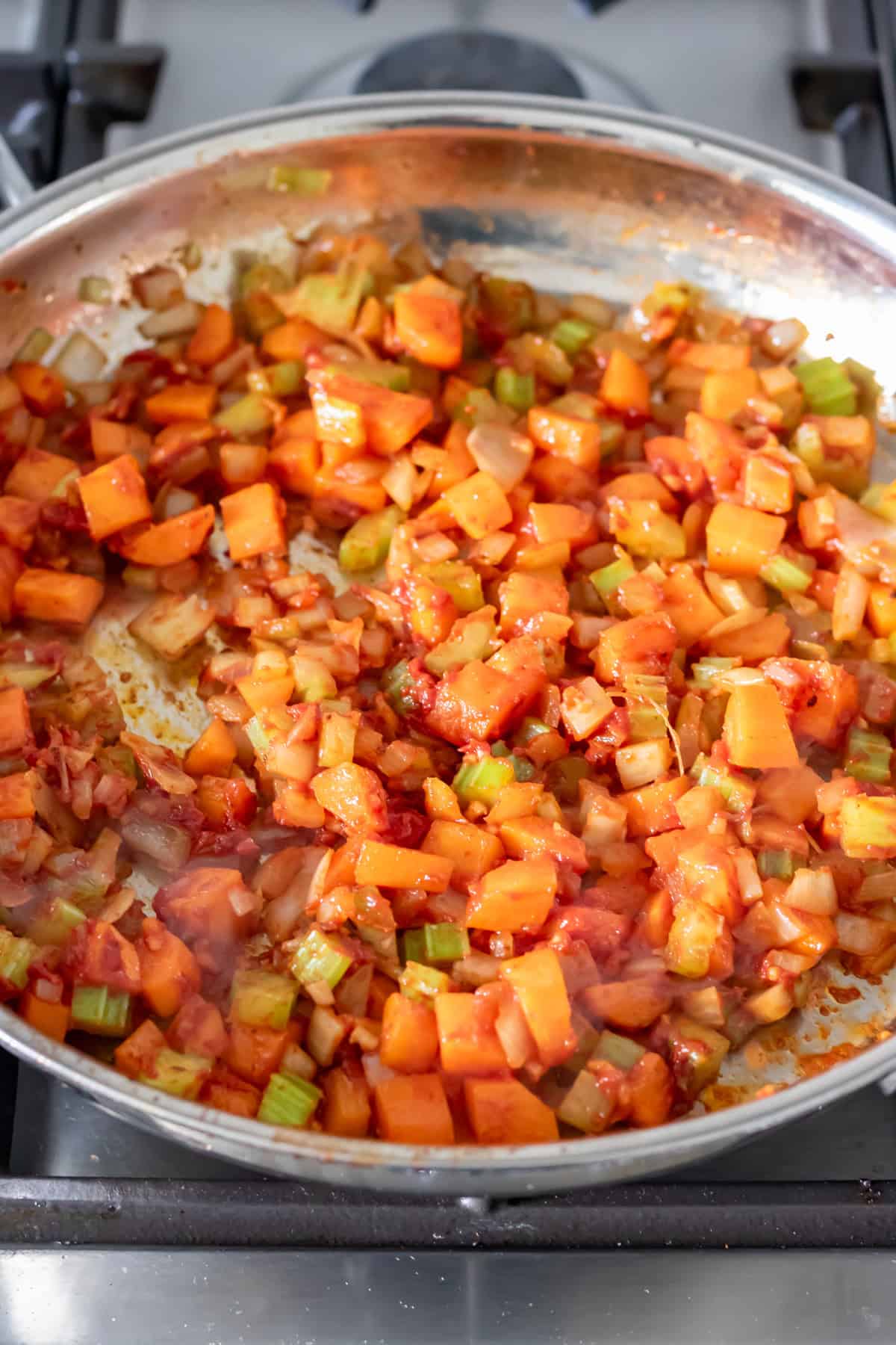 Adding tomato paste to the pan.