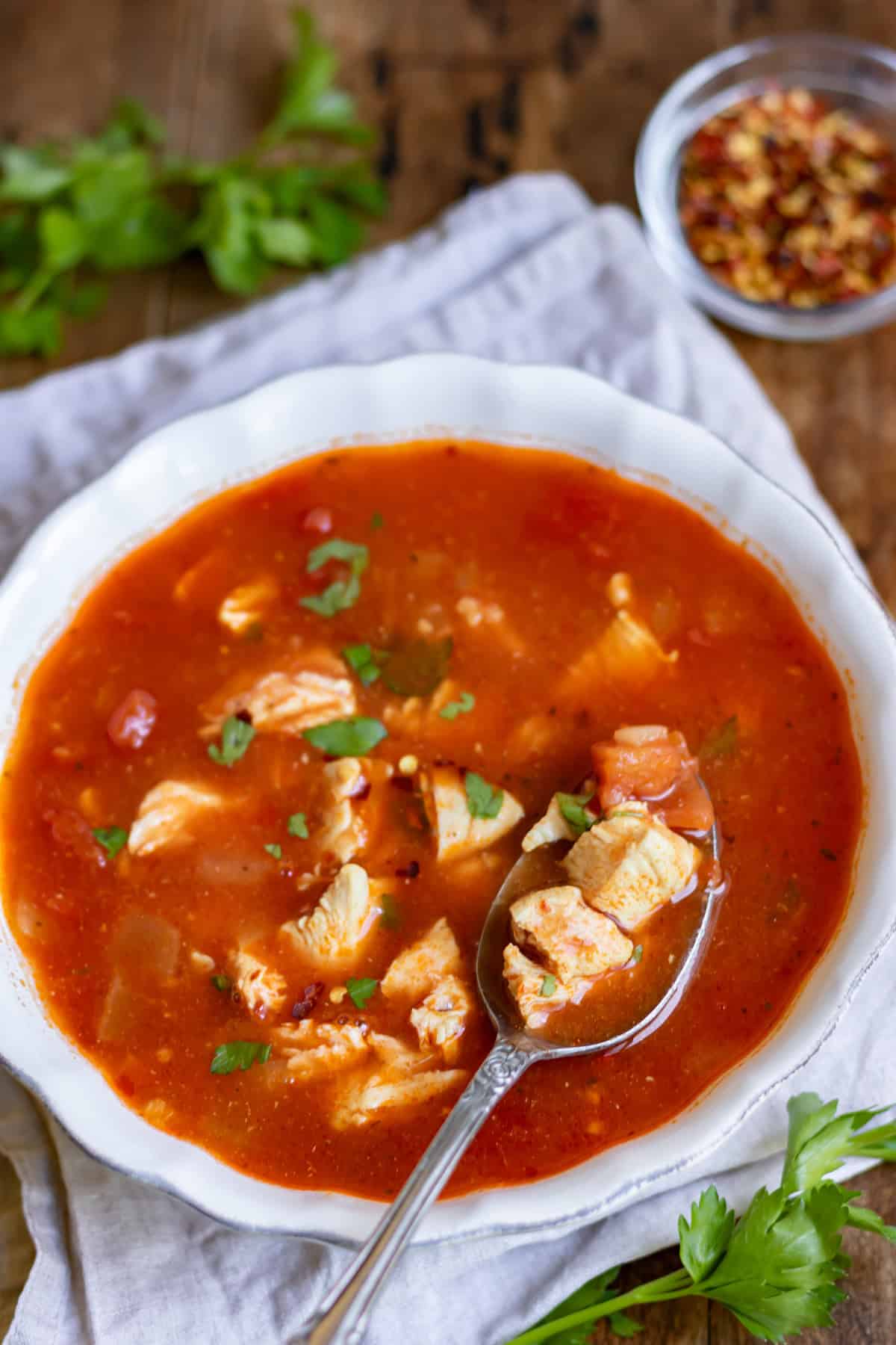 A spoonful of spicy chicken soup in the bowl.