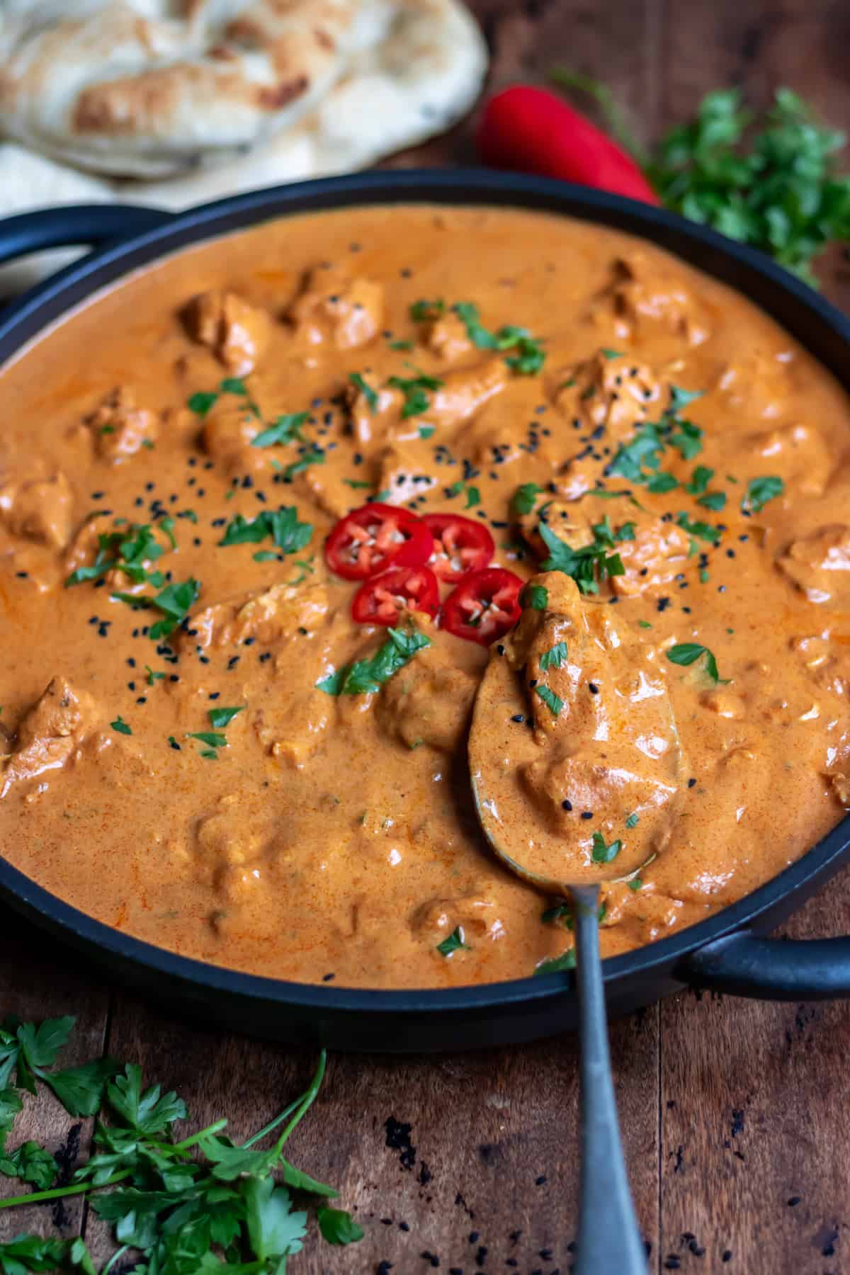 Spoon in a dish of slow cooker chicken tikka masala.