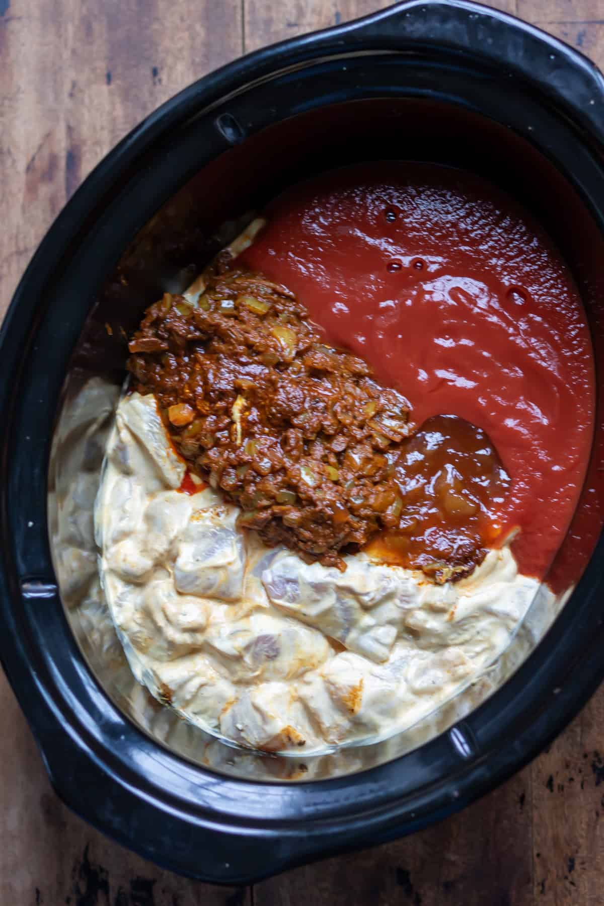 Yogurt coated chicken in the slow cooker along with onion tikka paste, tomato and mango chutney.
