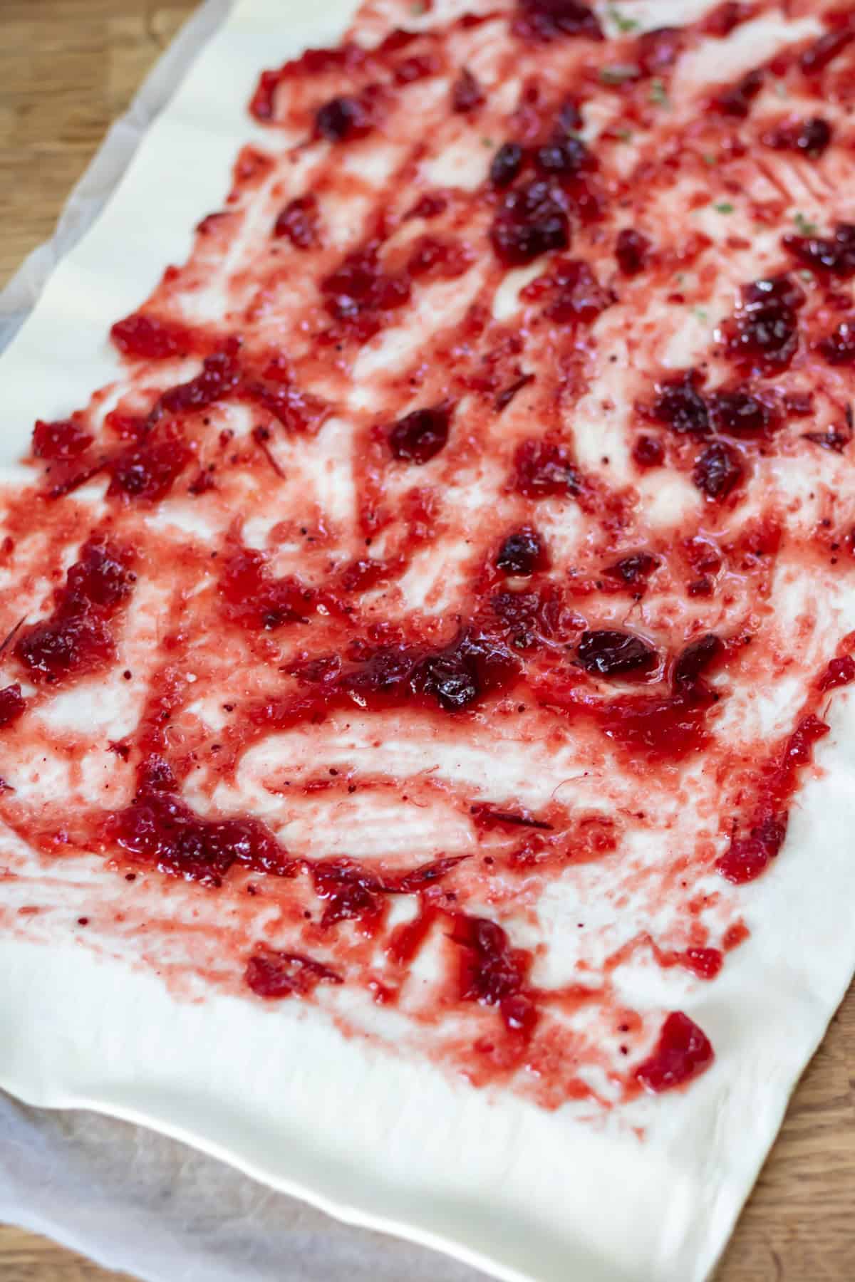 Spreading the pastry with cranberry sauce.