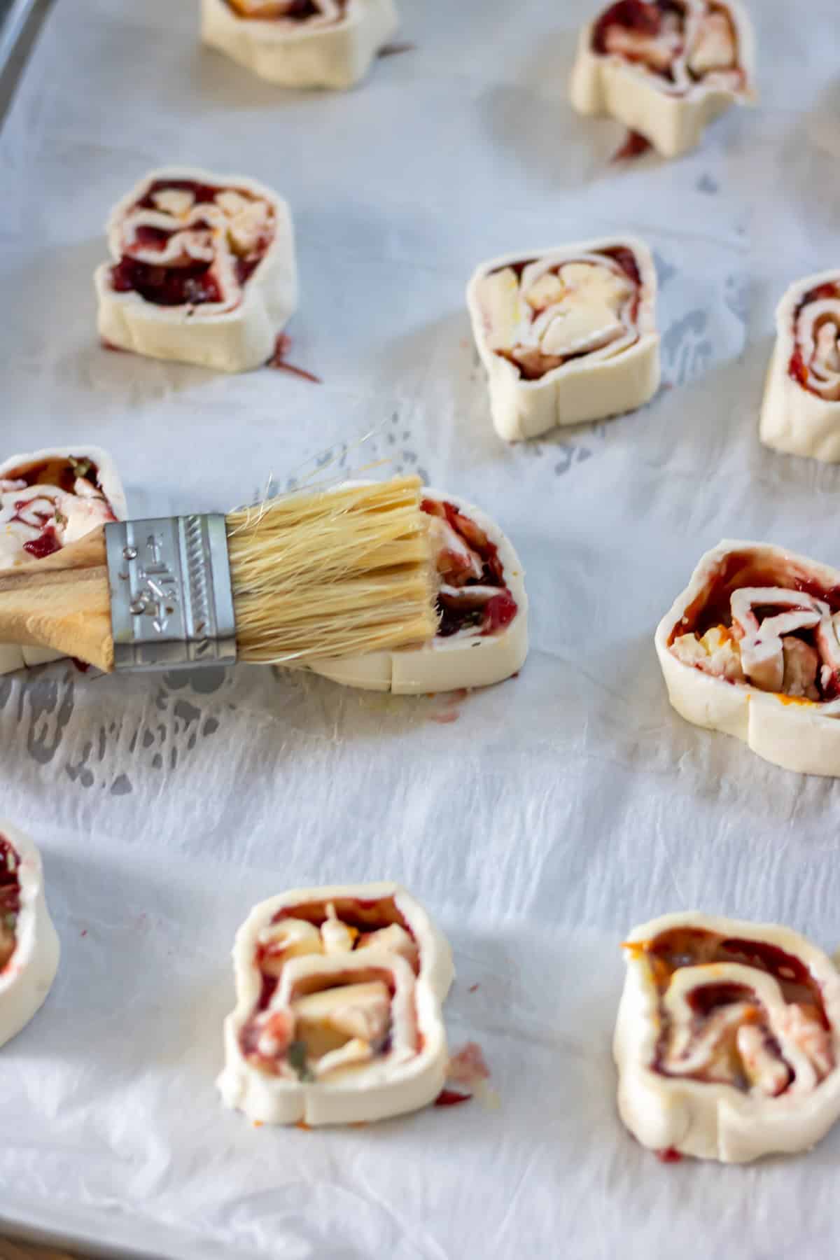 Brushing each pinwheel with beaten egg.