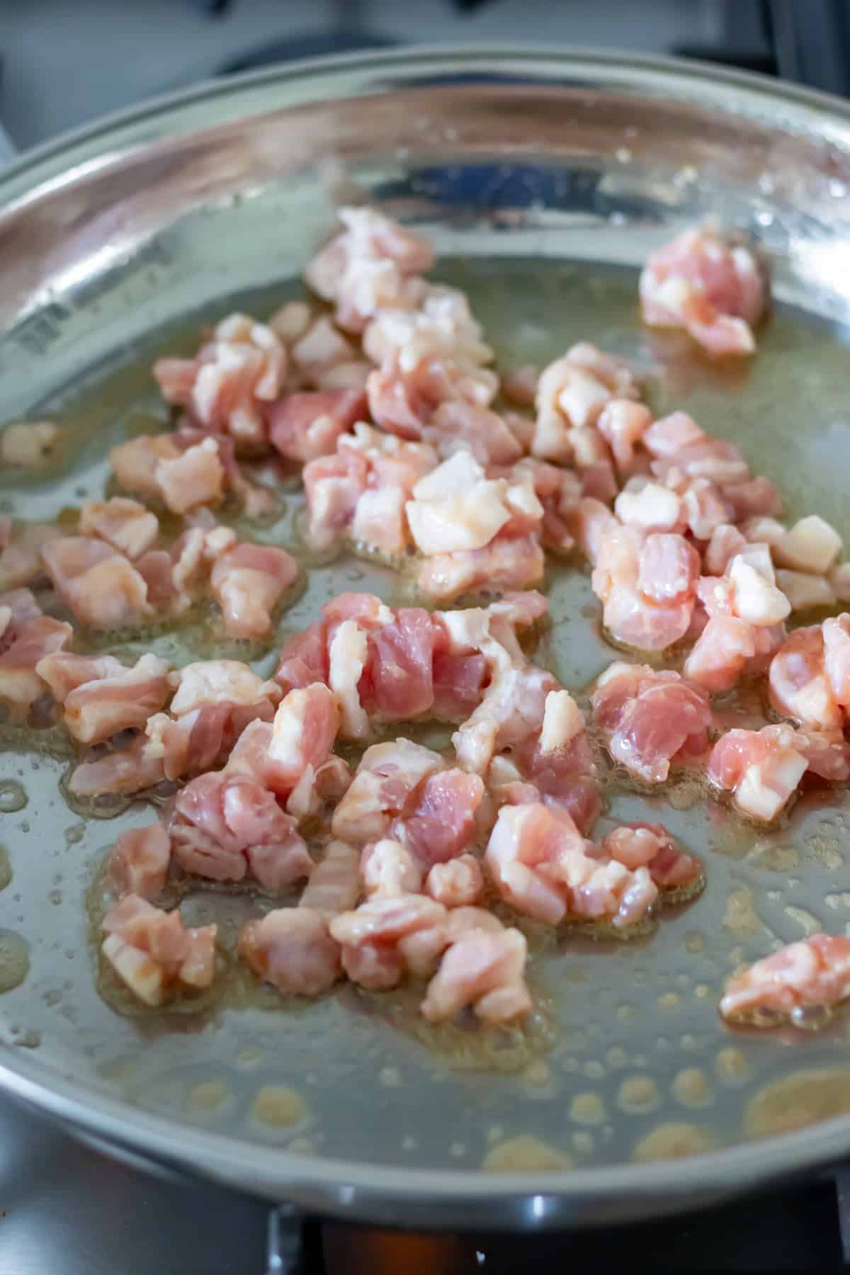 Bacon lardons in a skillet.