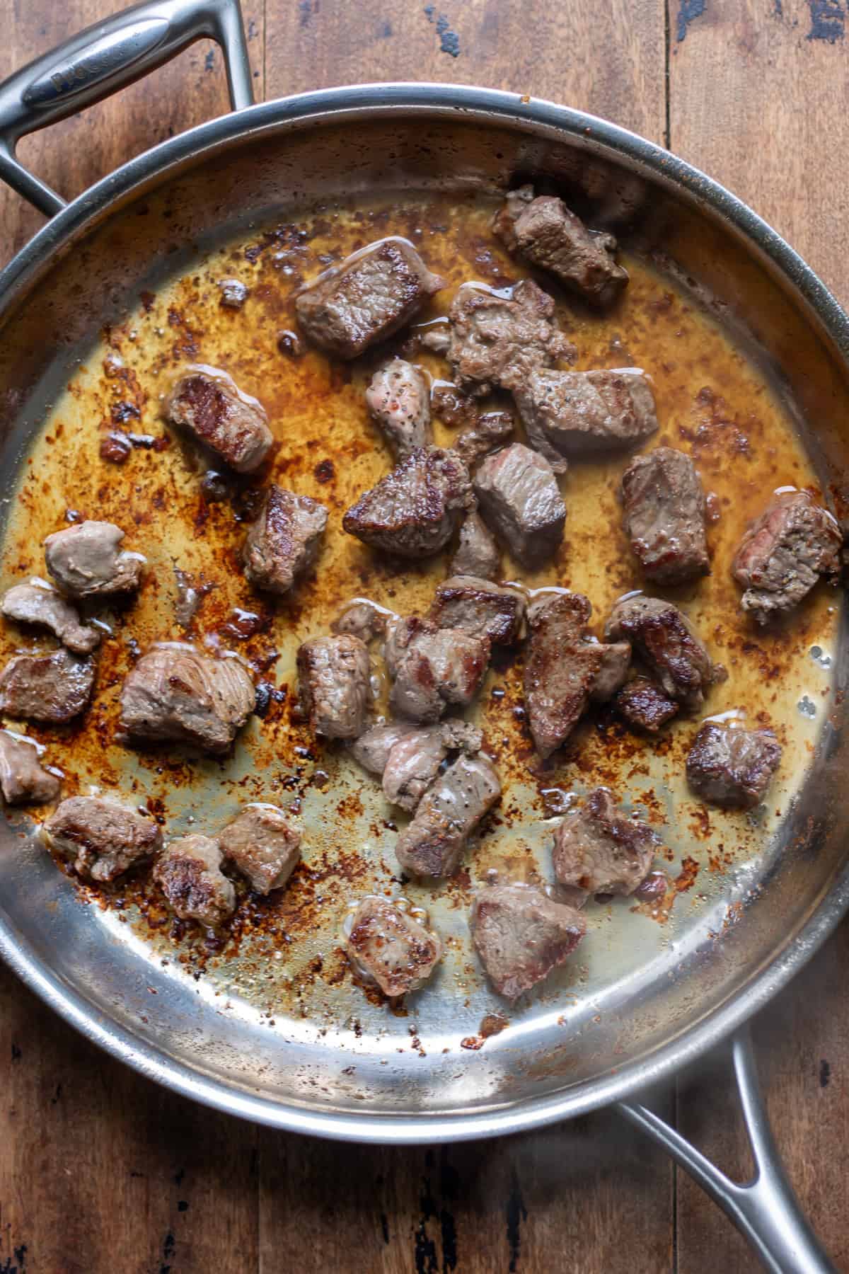 Browning the beef cubes in a skillet.