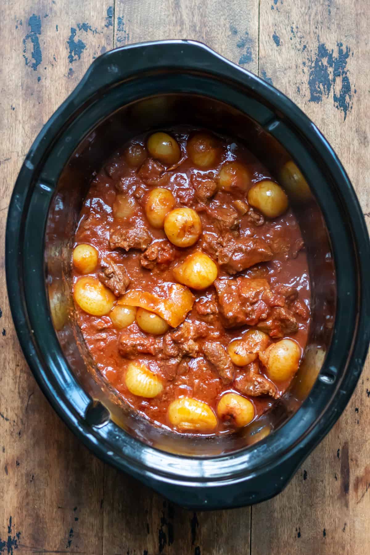 Partially cooked Greek Stifado in the slow cooker.
