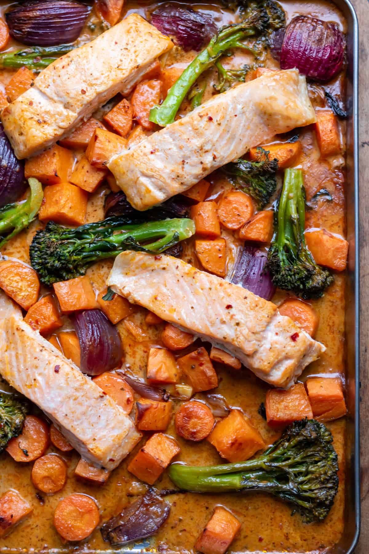 Close up of a sheet pan of baked Thai salmon and vegetables.