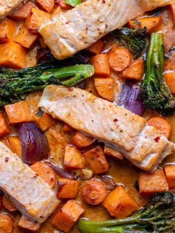Close up of a sheet pan of baked Thai salmon and vegetables.