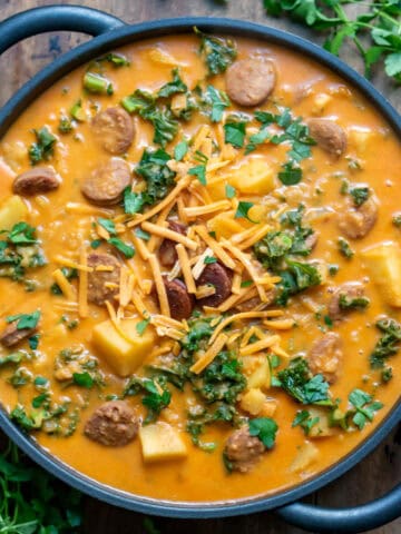 A serving dish of chorizo potato soup on a table.
