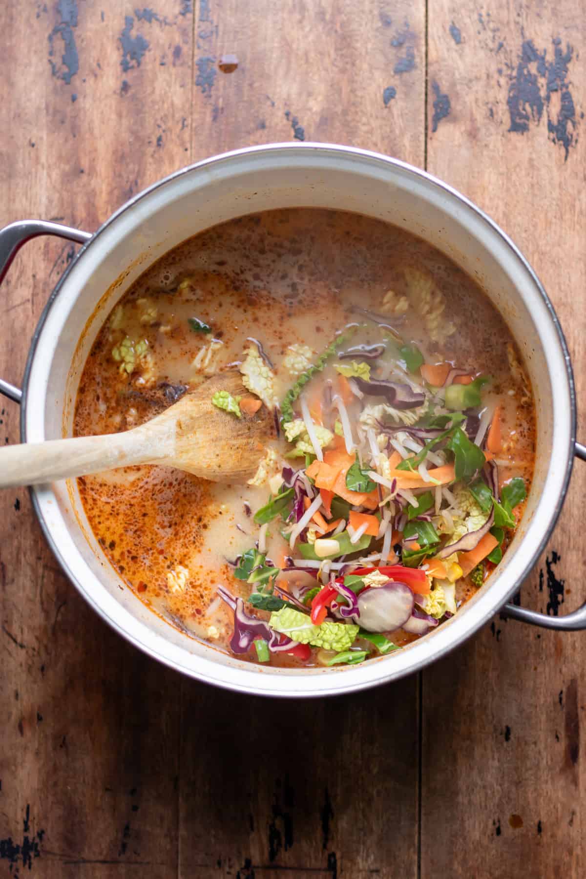 Vegetables stirred into the pot.