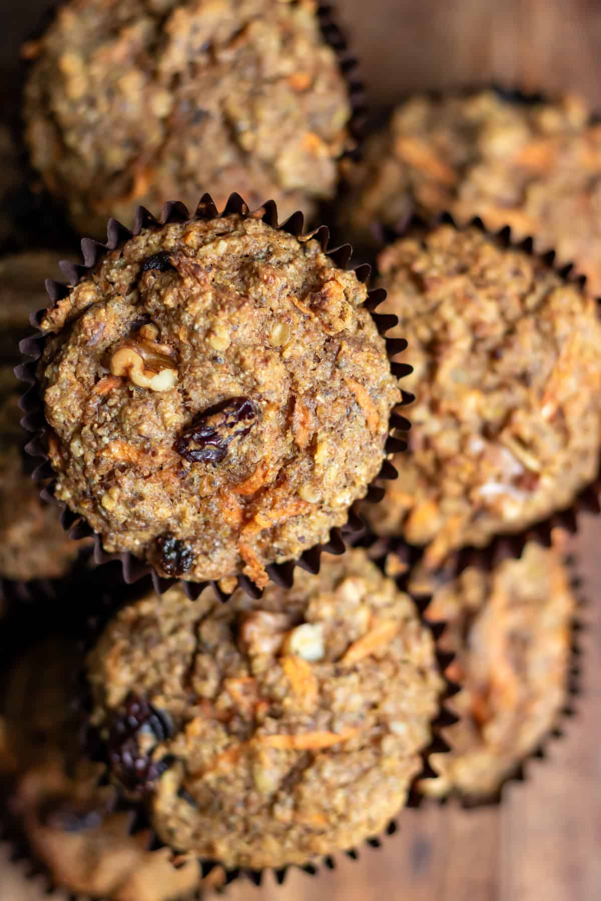 Close up of a carrot cake high fiber muffin on top of the pile.