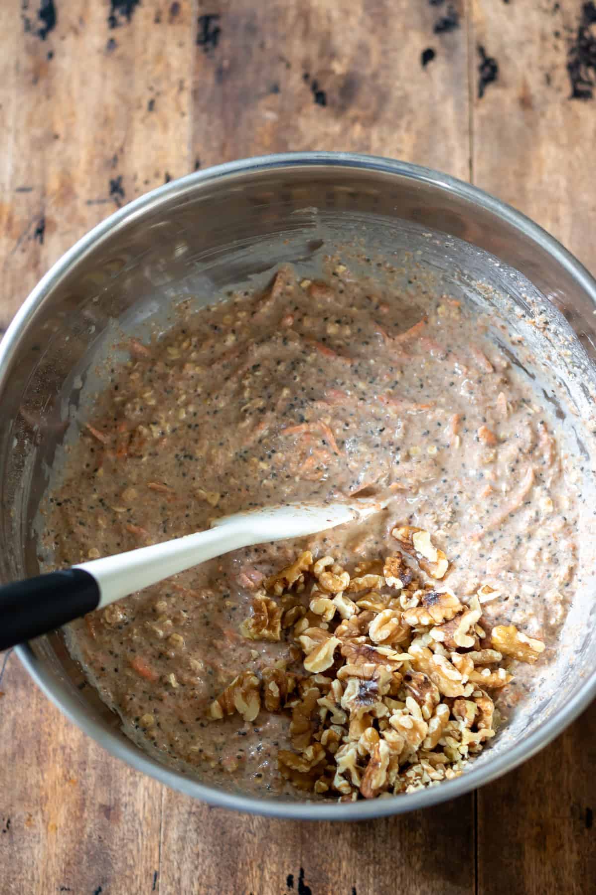 Mixing chopped walnuts into the batter.
