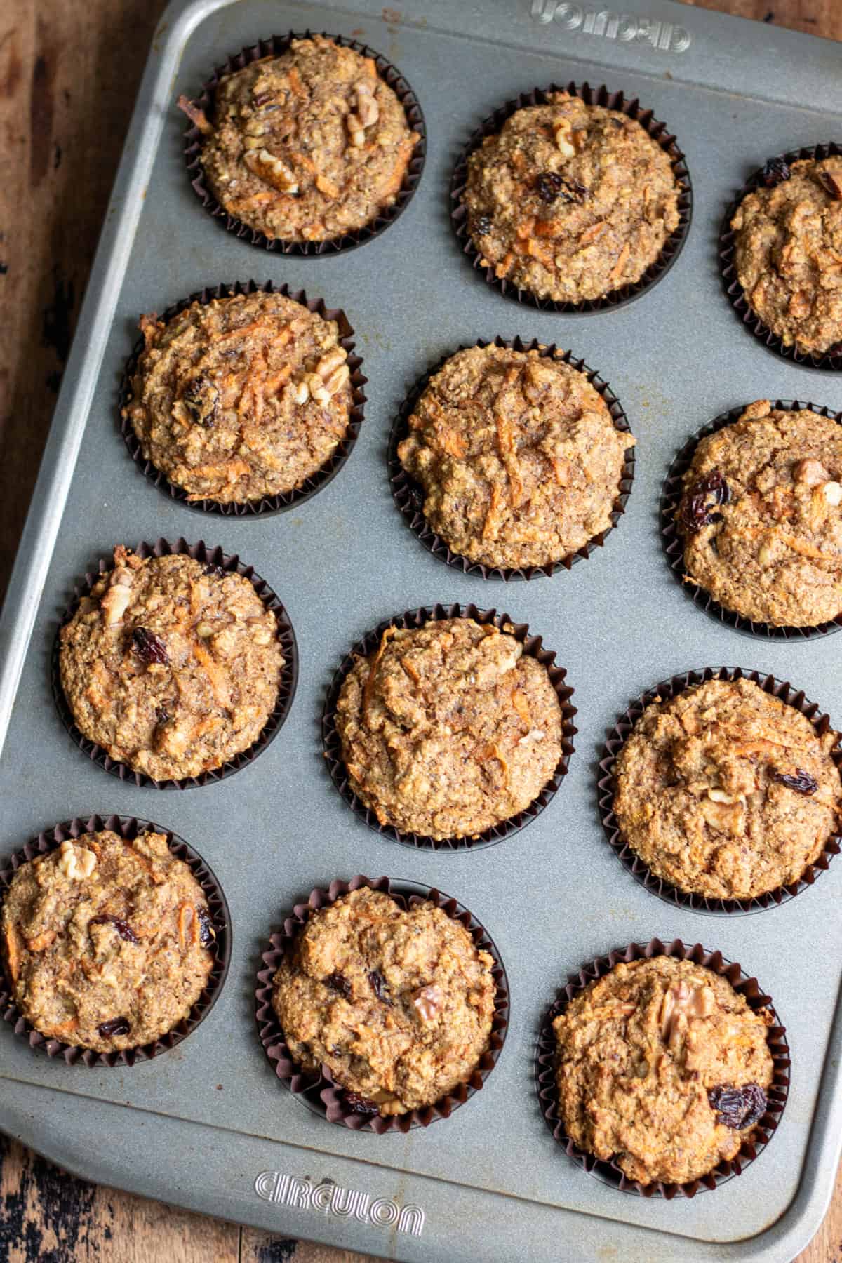 A muffin pan of baked carrot cake high fiber muffins.