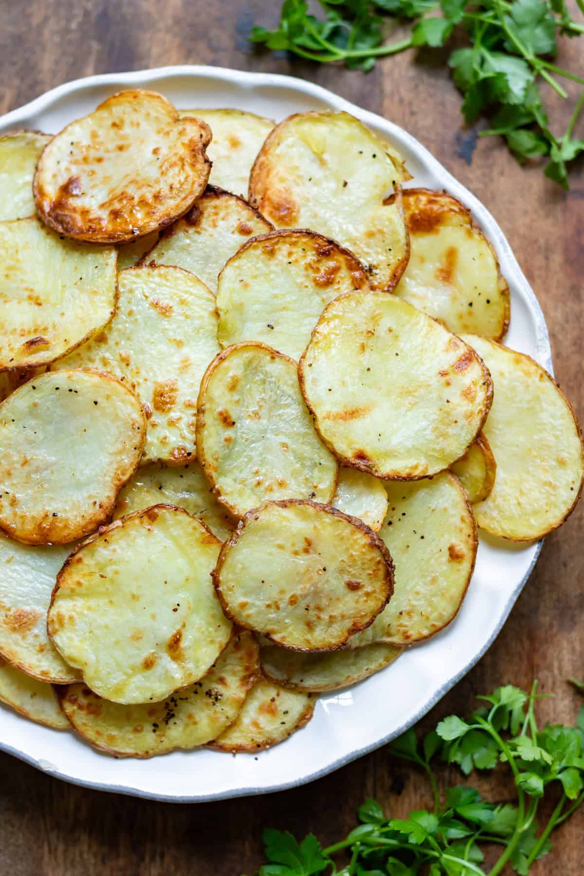 Close up of a plate of air fried crispy sliced potatoes.