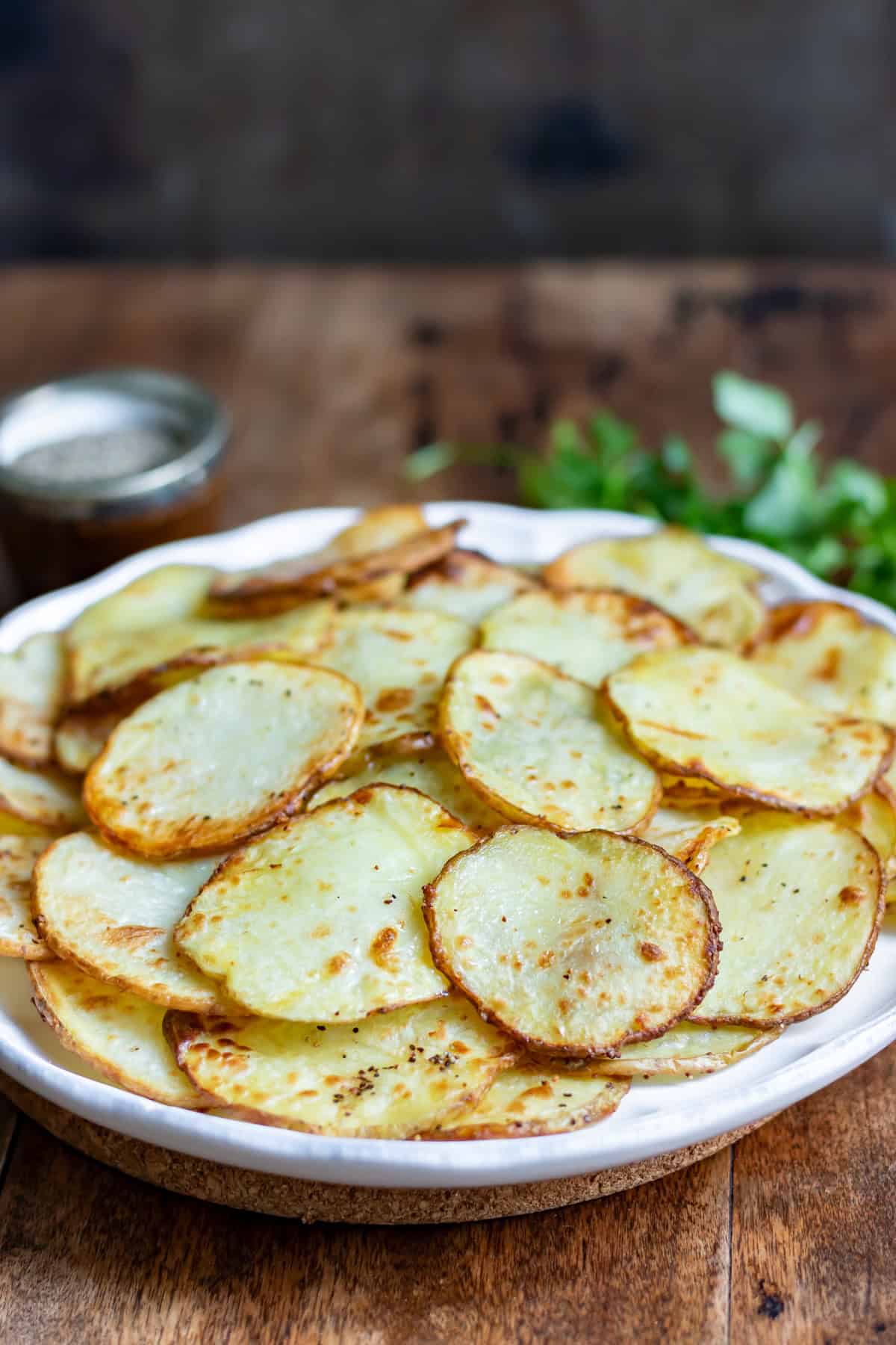 Side view of a plate of air fryer sliced potatoes.