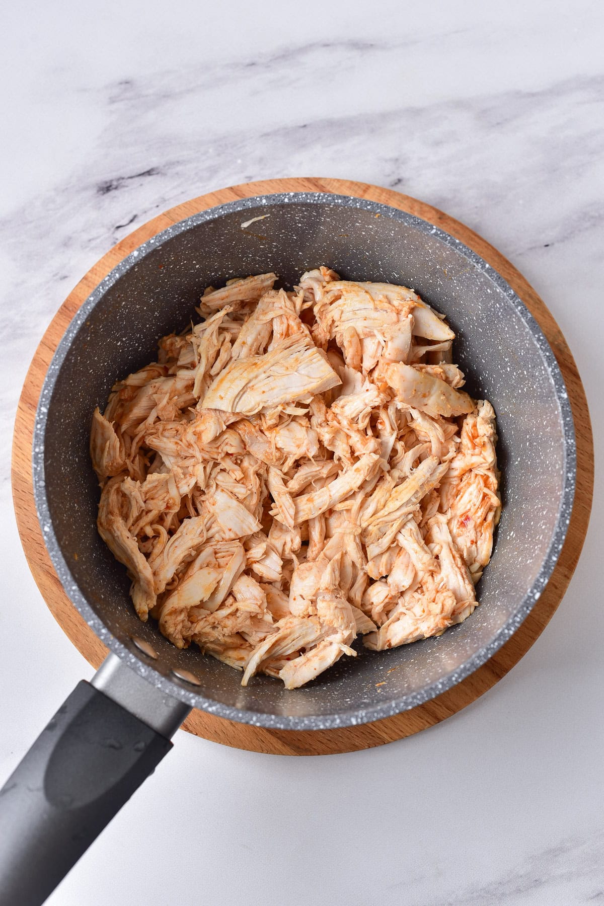 Buffalo sauce and shredded chicken into a pot.