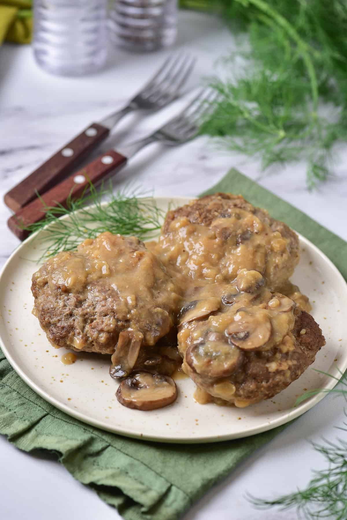 A table with a plate of salisbury steaks.
