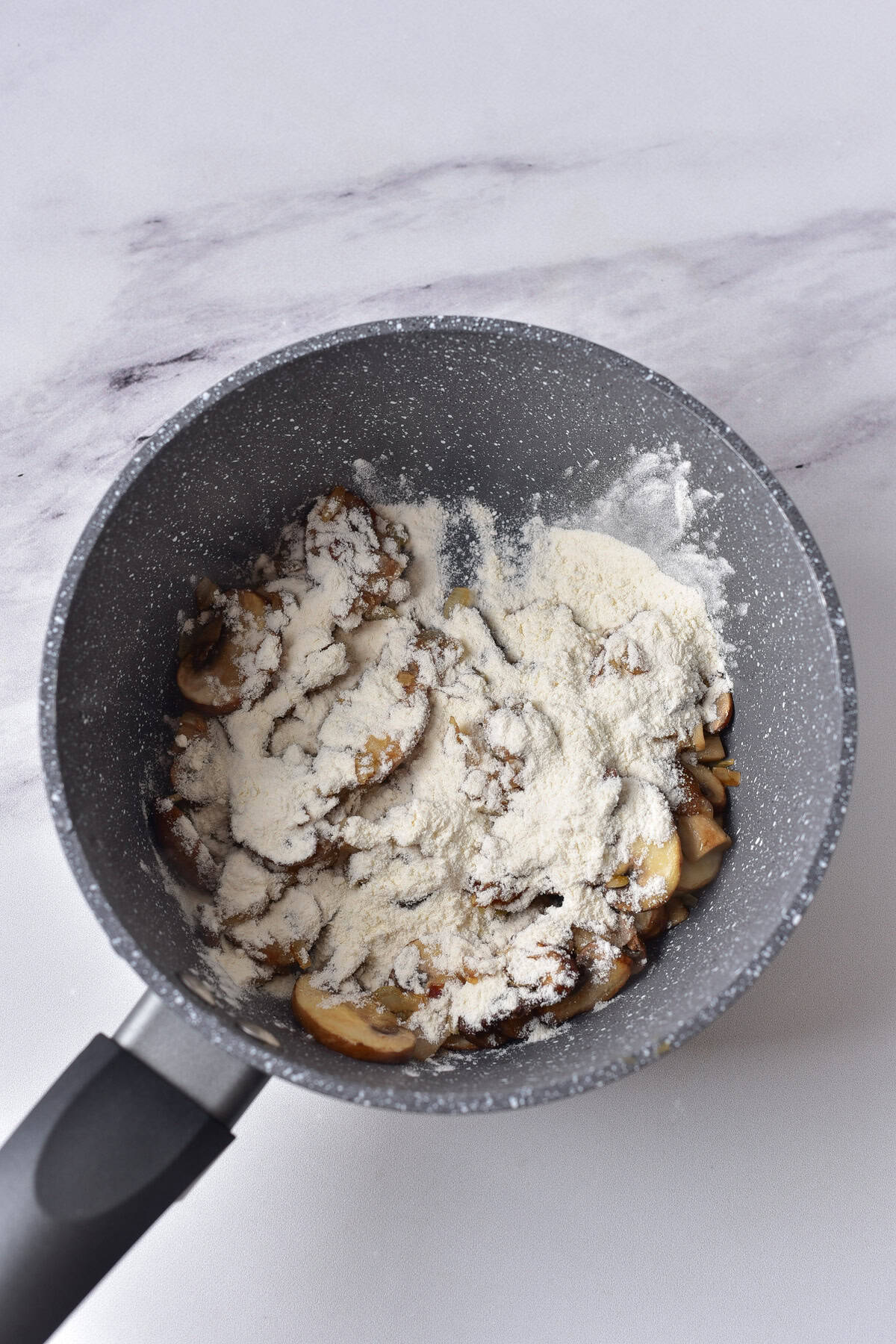 Flour in with the mushrooms in a pan.