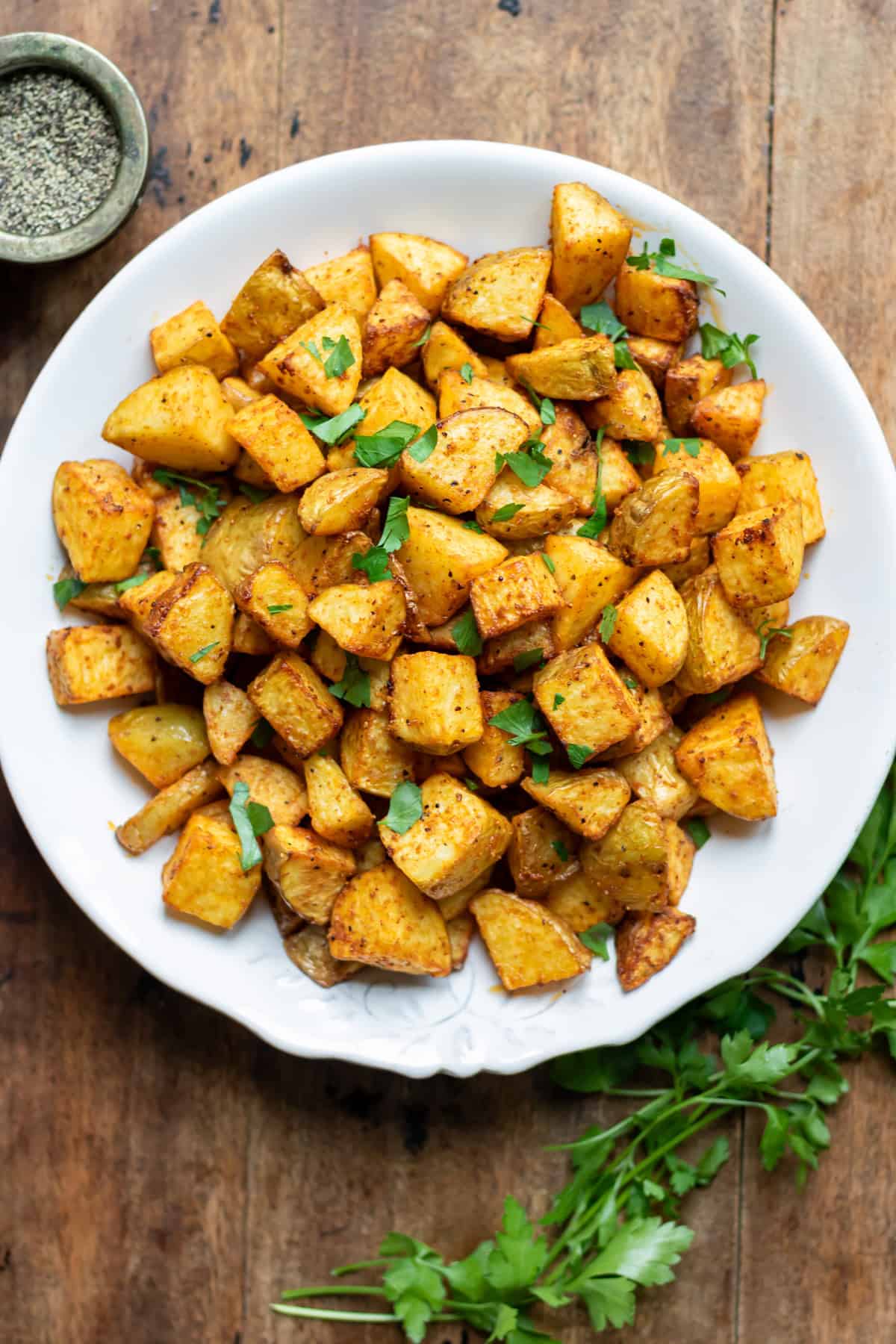 Looking down at a serving dish of crispy air fryer diced potatoes.