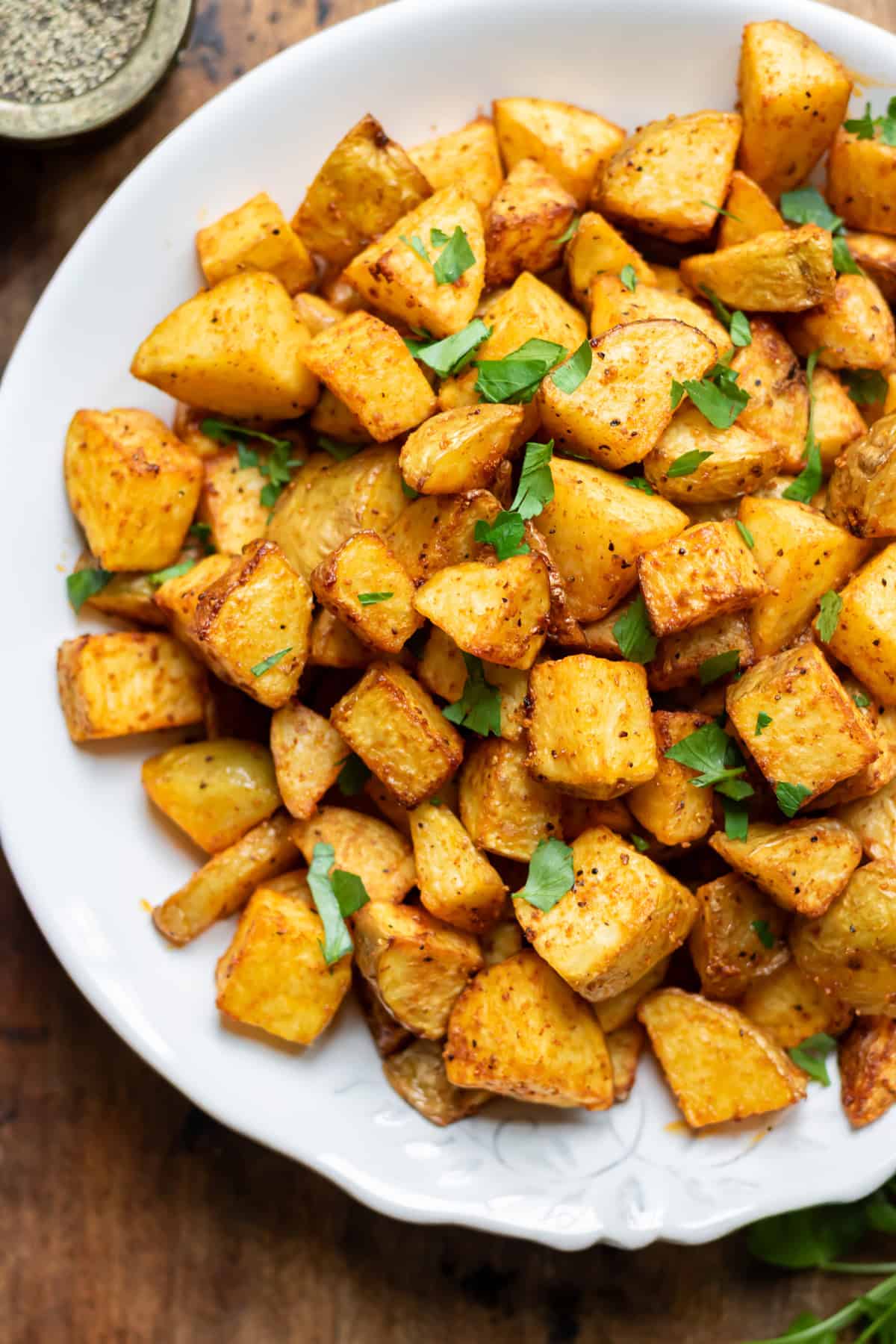 Close up of a serving dish of air fryer diced potatoes.