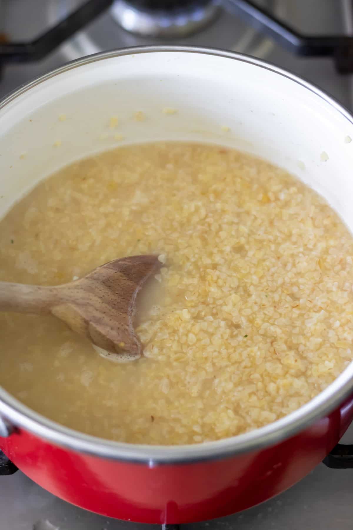 Cooking bulgur wheat in a pot.