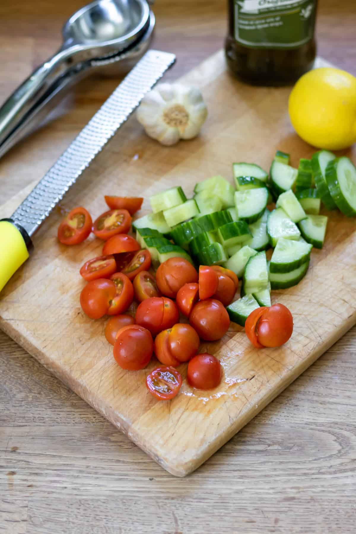 Chopping the cucumber and cherry tomatoes.