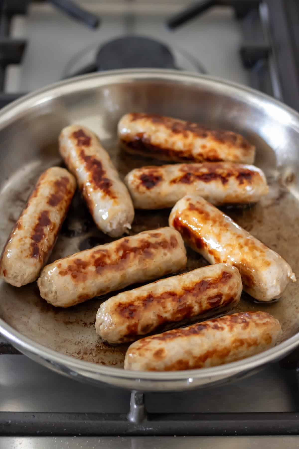 Browning the sausages in a frying pan.