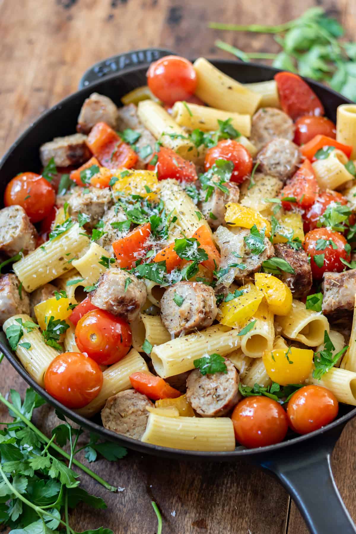 A skillet of Italian sausages, peppers and pasta.