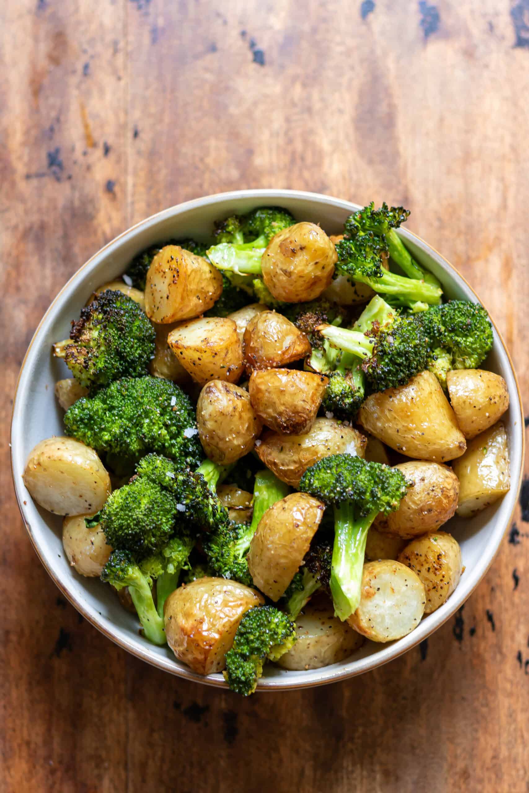 Serving dish of garlic roasted potatoes and broccoli.