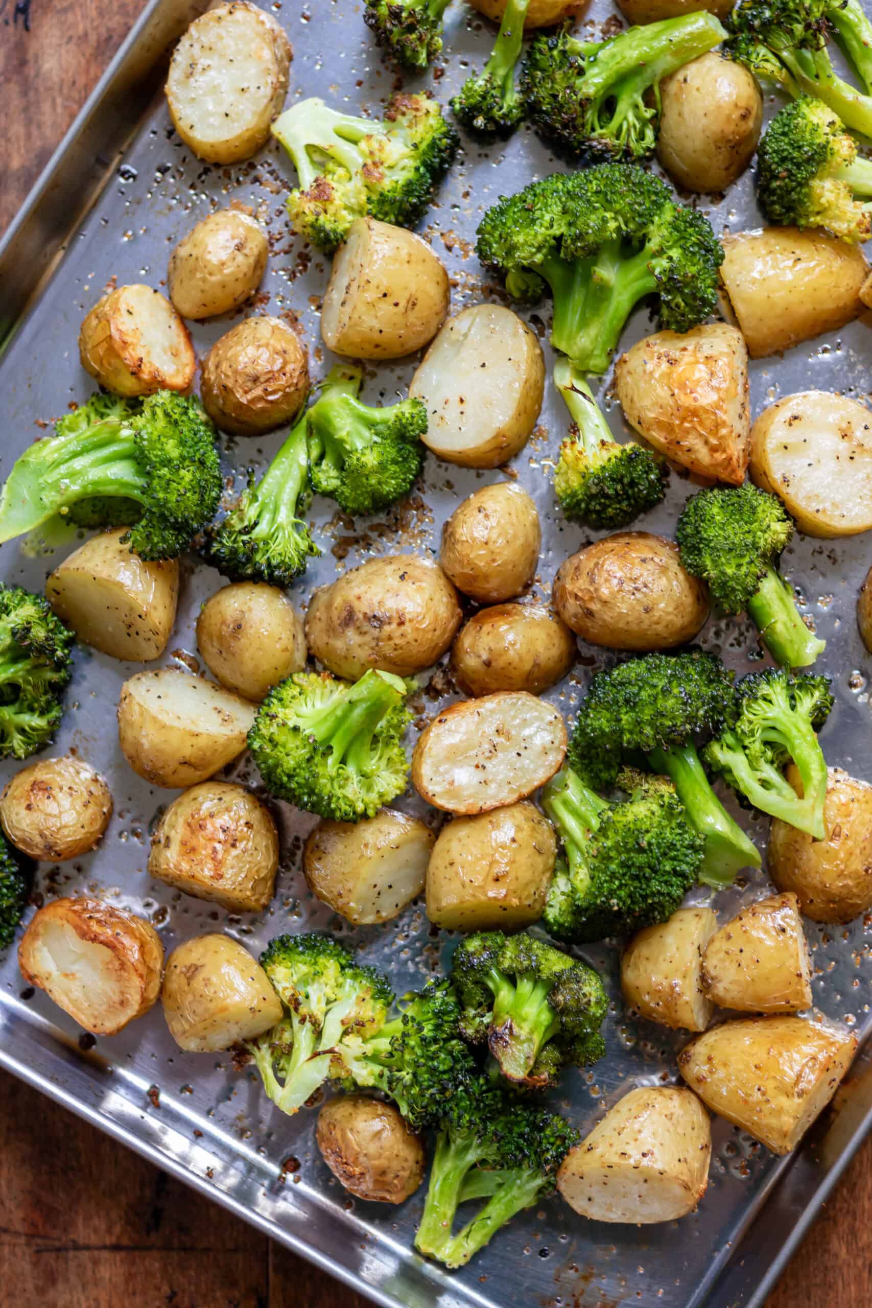 Close up of a baking sheet with garlic roasted potatoes and broccoli.