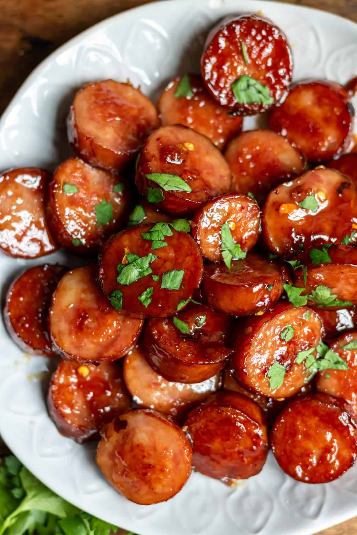 Plate of sliced smoked sausage in a hot honey sauce.