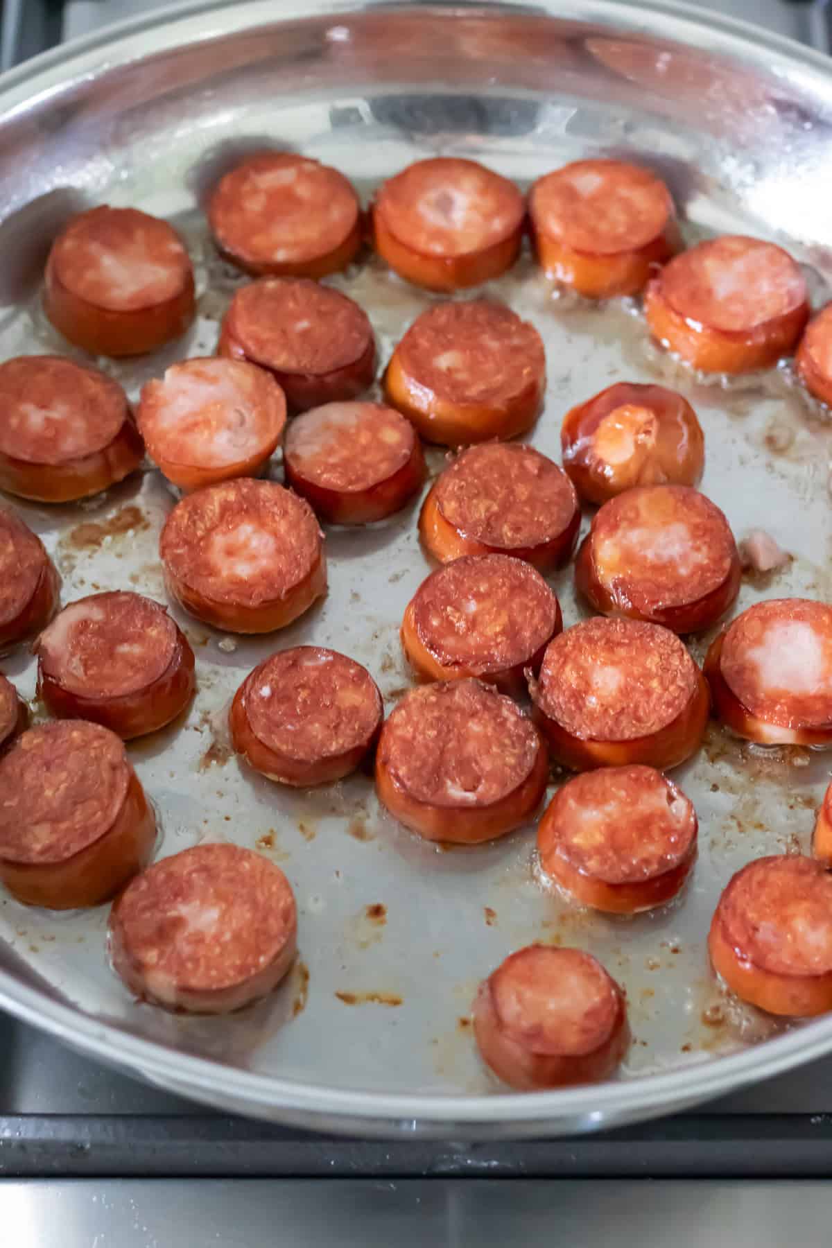 Cooking the smoked sausage in a frying pan.