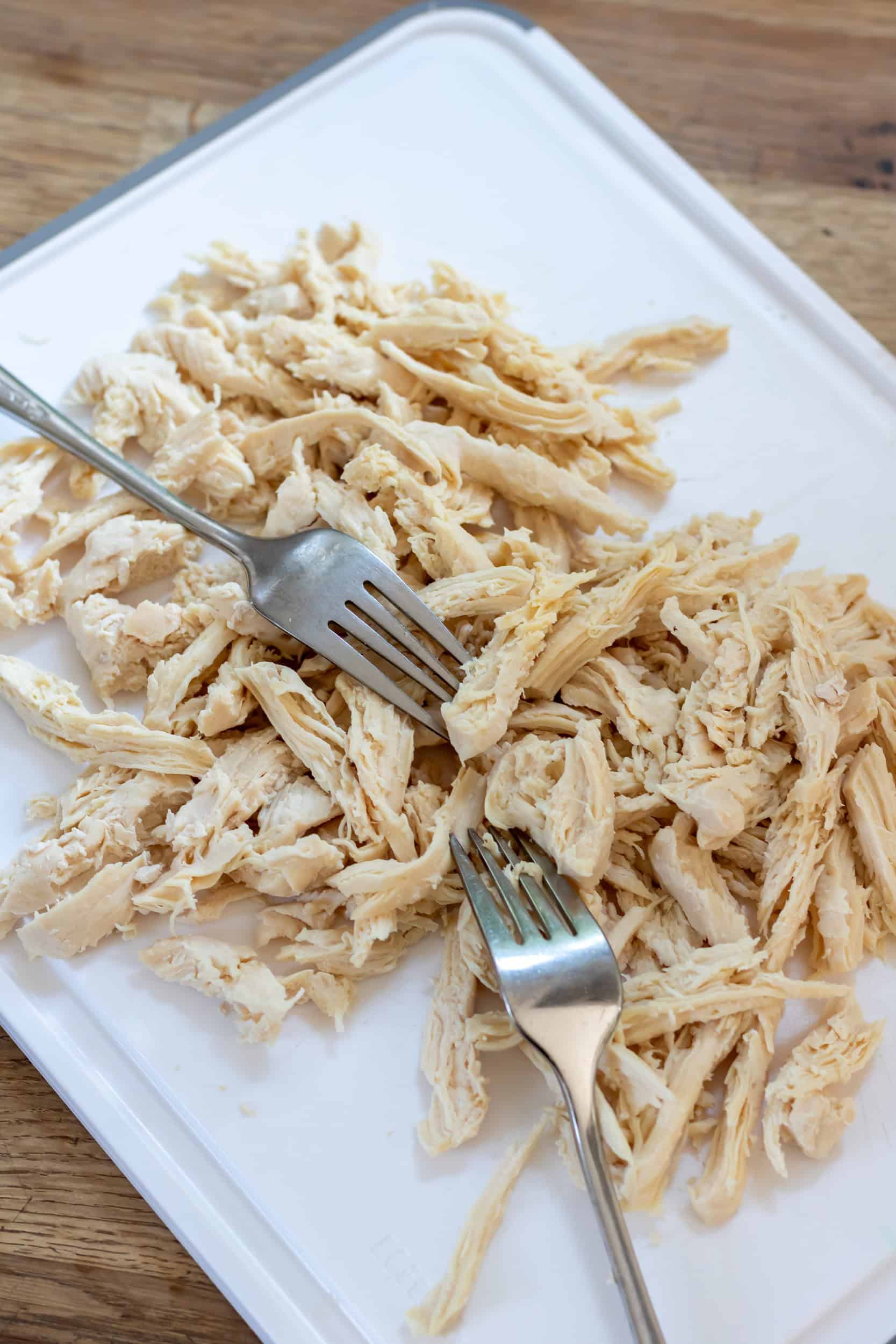 Shredding chicken breasts with two forks.