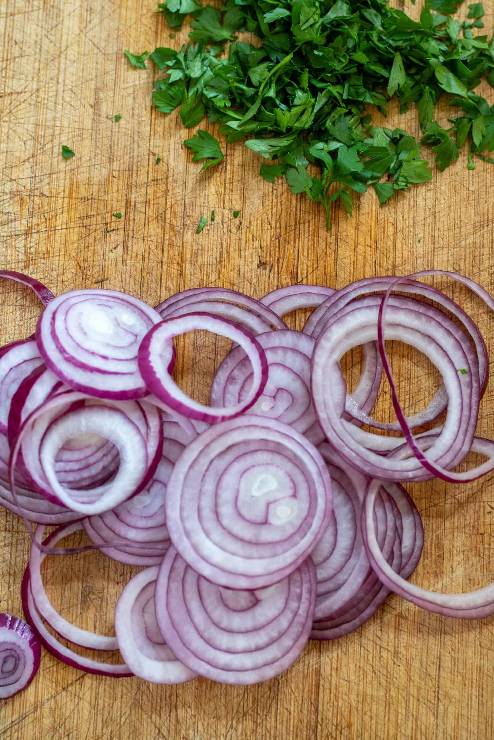 Chopping parsley and finely slicing red onion.